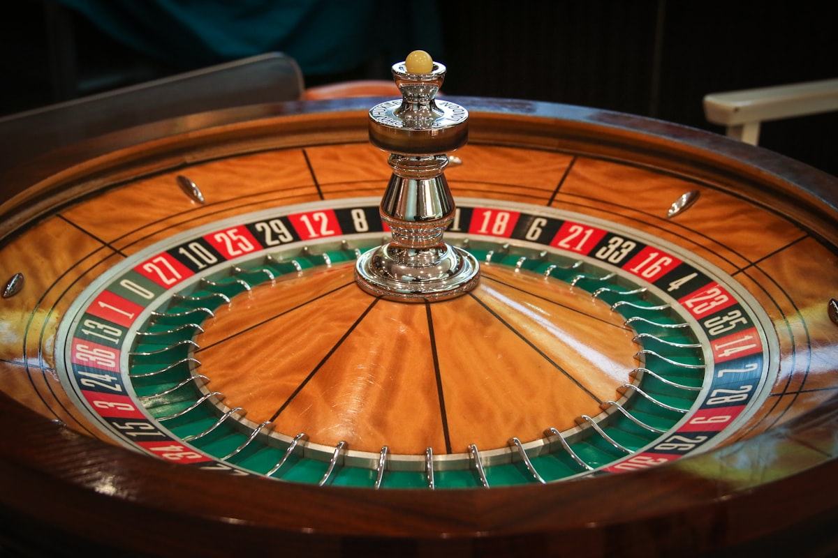 Meja roulette dengan roda dan keping warna di kasino