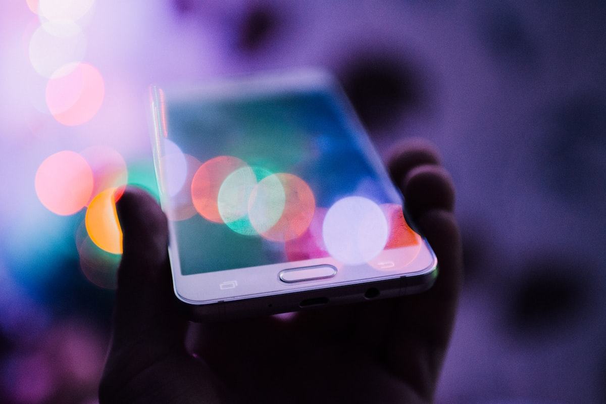 Pembaca memegang ponsel pintar sambil membaca informasi game digital