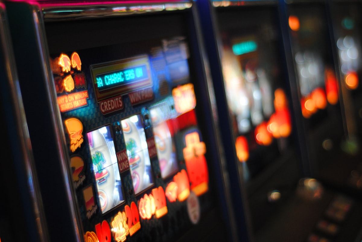 Mesin slot dengan lampu menyala di lantai kasino